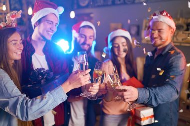 Arkadaşlar eğlenmeye grup. Genç insanlar güler. Yeni yıl birlikte kutluyor. Grup Noel Baba şapkaları güzel genç insan. Arka plan bulanıklık