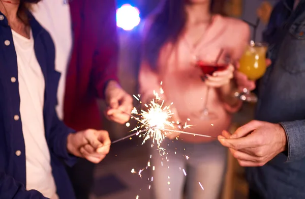 一群朋友玩烟火 年轻人笑 一起庆祝新年 一群美丽的年轻人在圣诞老人的帽子 模糊背景 — 图库照片
