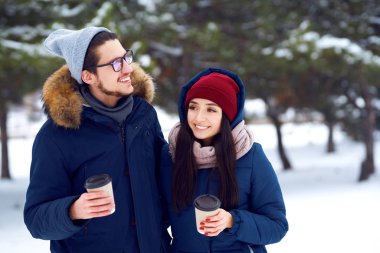 kış tatili, sıcak içecekler ve insanlar kavramı - kış orman kahve ile mutlu genç çift. insanlar kavramı - mutlu çift sıcak giysiler açık havada.                               