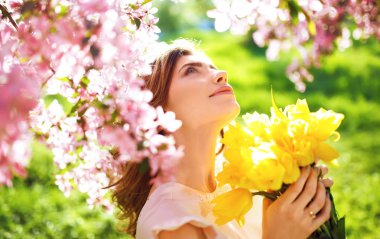Bahar tarzı. Lale bir buket ile güzel bahar elbiseli güzel genç esmer kadın. Güzel bahar bahçe. Moda bahar yaz fotoğraf