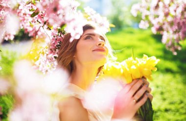 Bahar tarzı. Lale bir buket ile güzel bahar elbiseli güzel genç esmer kadın. Güzel bahar bahçe. Moda bahar yaz fotoğraf