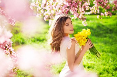 Bahar tarzı. Lale bir buket ile güzel bahar elbiseli güzel genç esmer kadın. Güzel bahar bahçe. Moda bahar yaz fotoğraf