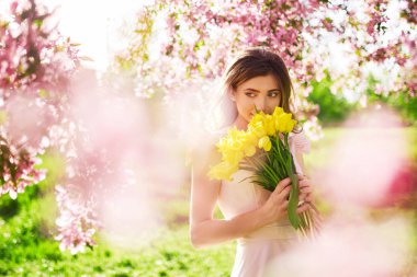 Bahar tarzı. Lale bir buket ile güzel bahar elbiseli güzel genç esmer kadın. Güzel bahar bahçe. Moda bahar yaz fotoğraf