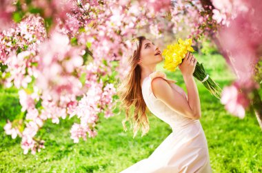 Bahar tarzı. Lale bir buket ile güzel bahar elbiseli güzel genç esmer kadın. Güzel bahar bahçe. Moda bahar yaz fotoğraf