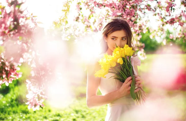Bahar tarzı. Lale bir buket ile güzel bahar elbiseli güzel genç esmer kadın. Güzel bahar bahçe. Moda bahar yaz fotoğraf