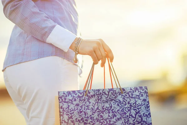 Beautiful girls with packages after shopping A picture of a group of happy friends shopping in the city. Girls walking around the city after shopping. good mood. Evening light. shopping concept