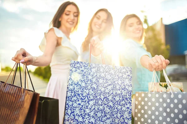 Bir grup şehirde alışveriş mutlu arkadaşıyla resmini alışveriş sonra paketleri ile güzel kızlar. Kızlar alışveriş sonra şehirde yürüyüş. iyi bir ruh hali. Akşam ışığı. alışveriş kavramı
