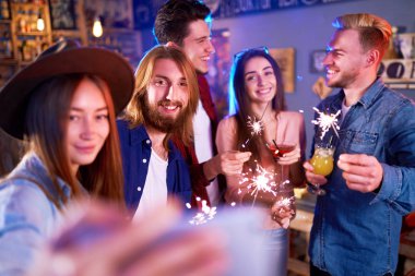 Selfie Time.Young grup arkadaşıyla birlikte bir gece kulübünde parti ve içecekler kızartma. Mutlu gençlerle maytap barda. İnsanlar büyük bir ruh var ve onlar çok gülümseme.