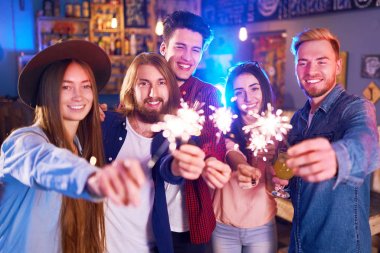 Genç grup arkadaşıyla birlikte bir gece kulübünde parti ve içecekler kızartma. Mutlu gençlerle maytap barda. İnsanlar büyük bir ruh var ve onlar çok gülümseme.