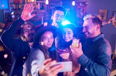 Selfie zaman. Genç grup arkadaşıyla birlikte bir gece kulübünde parti ve içecekler kızartma. Mutlu gençlerle barda kokteyller. İnsanlar büyük bir ruh var ve onlar çok gülümseme