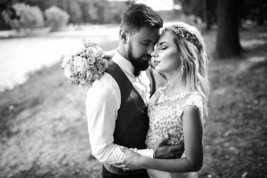 Düğün günü parkta poz mutlu yeni evliler şık birkaç. Mükemmel bir çift gelin, damat poz ve öpüşme 