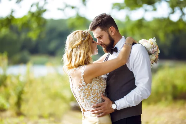 結婚式の日に公園でポーズをとって幸せな新婚夫婦のスタイリッシュなカップル パーフェクト カップル花嫁 新郎のポーズとキス — ストック写真