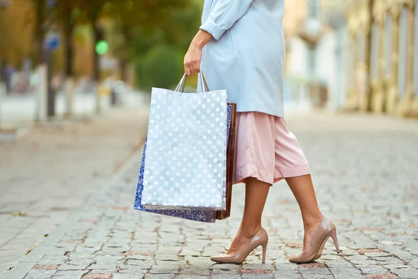コピー スペースが付いている通りの買い物袋を持った女性のクローズ アップ ショッピング バッグで買い物を楽しんで幸せな女は 消費者のショッピング ライフ スタイル コンセプト — ストック写真