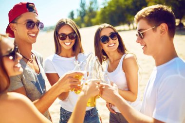 Grup arkadaşıyla sahilde bira dışarı asılı. Mükemmel güneşli havalarda. Güzel resimler. Süper ruh hali. Yaz konsepti.