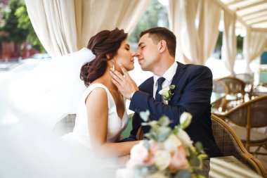 Genç gelin ve damat bir kafede. Karı koca el ele tutuşuyorlar. Lokantada birbirini seven bir çift. Damat bir gelini öpüyor. Güzel gelin ve şık damat. Düğün günü. Evlilik..