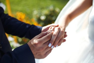 Nişan yüzükleri. Nişan yüzükleri takan yeni evli çiftlerin elleri. Törendeki genç çift. Nişan yüzüklü gelin ve damat. Eremony düğün günü. Düğün ayrıntılarını kavra.