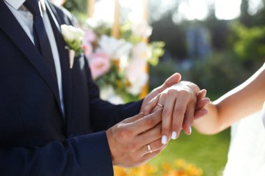 Nişan yüzükleri. Nişan yüzükleri takan yeni evli çiftlerin elleri. Törendeki genç çift. Nişan yüzüklü gelin ve damat. Eremony düğün günü. Düğün ayrıntılarını kavra.
