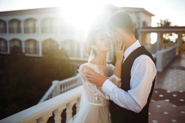 Parmağındaki bir yüzük. Güzel gelin ve şık damat birbirlerinden hoşlanıyorlar. Siyah takım elbiseli bir damat beyaz elbiseli güzel bir gelini nazikçe kucaklıyor. İlişki aşkı kavramı. Birlikte. 