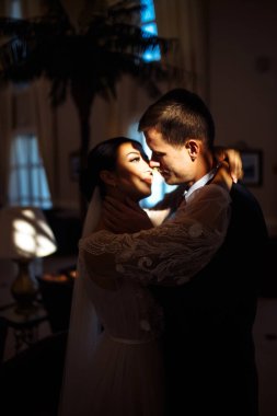 Karanlıktaki genç evli çift. Yeni evliler birbirlerini nazikçe severler. Özel bir atmosfer. Lüks, zarif bir düğün çifti öpüşüyor ve sarılıyor. Romantik bir an. Birlikte. Düğün..