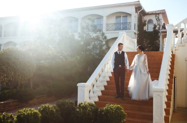 Gelin ve damat merdivenlerin basamaklarında. Zarif, şık, genç bir çift merdivenlerde sarılıp eğleniyor. Yeni evliler açık havada merdivenlerde poz veriyorlar. Birlikte. Düğün..