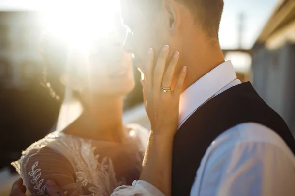 手指上的戒指 漂亮的新娘和时髦的新郎正在互相欣赏 身穿黑色西服的新郎轻柔地拥抱着身穿白衣的漂亮新娘 恋爱的概念 一起来 — 图库照片