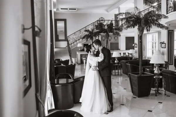 年轻夫妇享受浪漫的时刻 非常漂亮的婚礼一对了不起的夫妇 穿着黑色西服的时髦新郎轻柔地拥抱着身穿白衣的漂亮新娘 在一起 — 图库照片