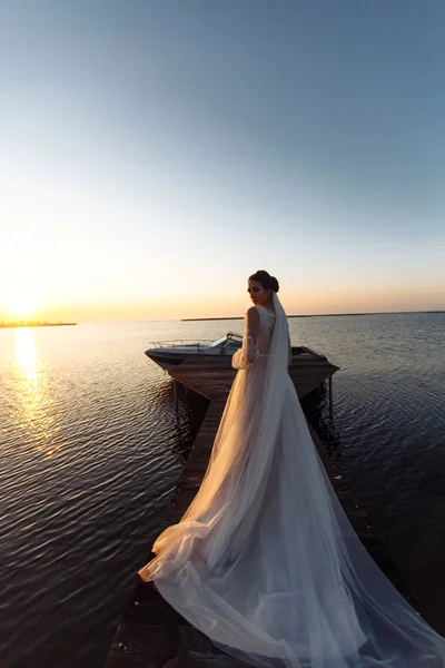 Krásná Nevěsta Elegantních Bílých Šatech Mostě Pozadí Moře Paprscích Západu — Stock fotografie