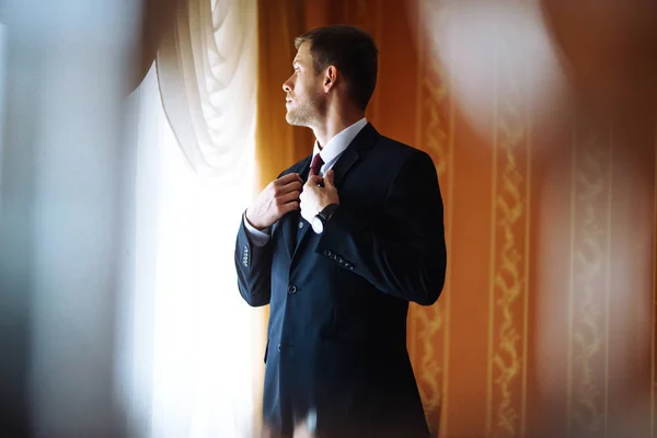 Luxury groom in suit. Businessman. Morning Groom Fees. The beginning of the wedding day. Stylish sexy man in suit posing. Men's fashion.