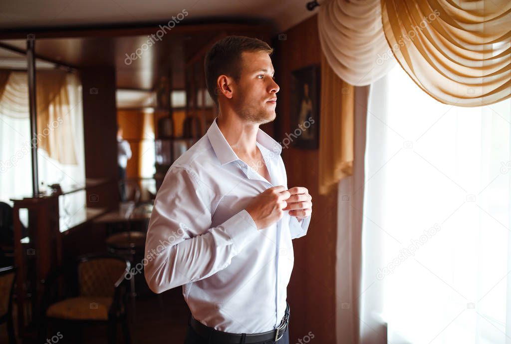 Luxury groom in suit. Businessman. Morning Groom Fees. The beginning of the wedding day. Stylish sexy man in suit posing. Men's fashion.