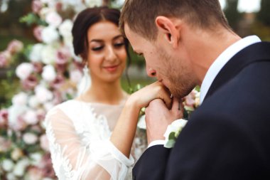 Nişan yüzükleri. Evli çiftler nikah töreninde alyanslarını takarlar. Damat, sevgili karısının parmağına yüzük taktı. Düğün detaylarını düşün. Mutlu bir aile. Birlikte.