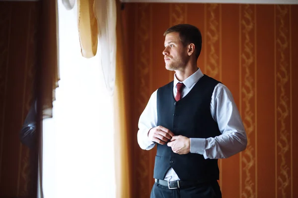 Luxury groom in suit. Businessman. Morning Groom Fees. The beginning of the wedding day. Stylish sexy man in suit posing. Men's fashion.
