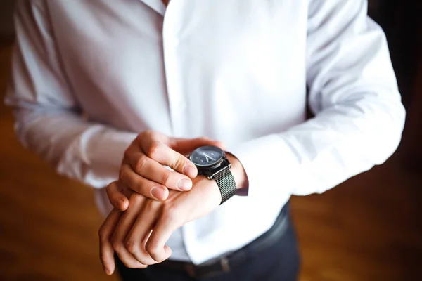 Stylish men\'s wrist watch, the man is watching the time. Businessman clock. Groom getting ready in the morning before wedding ceremony.  Businessman checking time on his wristwatch. Men Fashion.