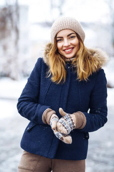 在冬天的森林里 美丽的女人站在雪树中间 年轻姑娘穿着蓝色夹克 头戴针织帽子 头戴手套 冬天快乐 在冬季公园里的时髦的年轻女子 圣诞节 — 图库照片