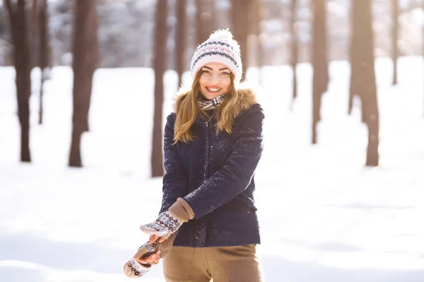 穿着蓝色夹克 头戴针织帽子 头戴手套 长发的年轻漂亮姑娘的画像 在阳光灿烂的冬日装扮 时尚的年轻女子在冬季的森林里 圣诞节 寒假概念 — 图库照片
