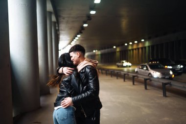 Genç çift birbirine sarılıyor ve yeraltı geçidinde eğleniyor. Bir çift adam ve kadın tünele giriyorlar. Birlikte olduğumuz için mutluyum. Aşk, romantik, tutku, şefkat konsepti.