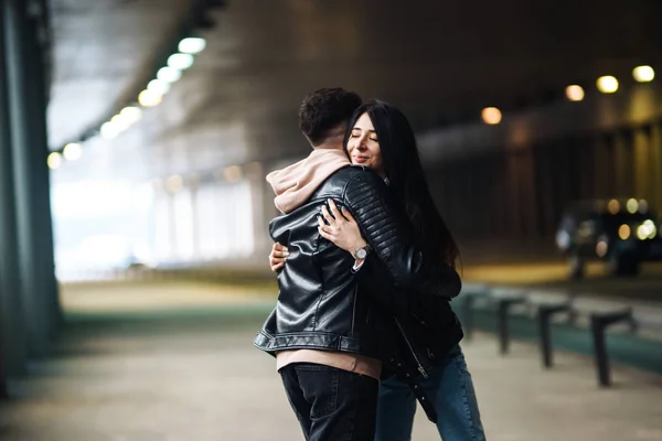 Young couple in love hug each other and have fun  in underground crossing. Couple of man and woman walking into a tunnel. Happy to be together. Love, romantic, passion, tenderness concept.