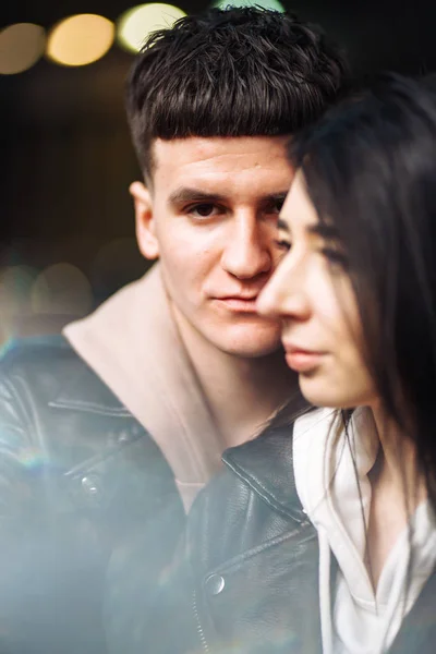 Portrait of sensual young couple in love. Young couple in love hug each other on the black background with lights. Together. Love, romantic, passion, tenderness  concept.