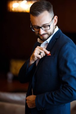 Takım elbiseli şık bir damat. İş adamı. Ceketli lüks damadın portresi. Damadın sabahı, damat masrafları. Takım elbiseli seksi adam. Düğün günü..