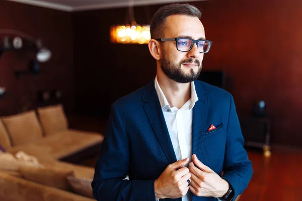 Elegant groom in suit. Businessman. Portrait of the luxury groom in a jacket. The morning of the groom, bridegroom's fees. Sexy man in suit posing. Wedding day.