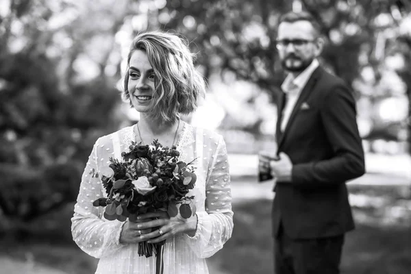 新娘和新郎的美丽的黑白照片 在公园里 这对快乐的夫妇穿着婚纱和婚纱摆姿势 面带微笑 人们互相享乐 在一起 结婚的概念 — 图库照片
