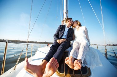 Düğün günü teknede, açık denizde güzel bir çift. Beyaz elbiseli zarif bir gelin ve lüks bir yatta denizde yüzen şık bir damat. Birlikte. Düğün günü..