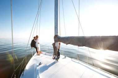 Düğün günü teknede, açık denizde güzel bir çift. Beyaz elbiseli zarif bir gelin ve lüks bir yatta denizde yüzen şık bir damat. Birlikte. Düğün günü..