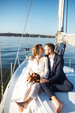 Düğün günü teknede, açık denizde güzel bir çift. Beyaz elbiseli zarif bir gelin ve lüks bir yatta denizde yüzen şık bir damat. Birlikte. Düğün günü..