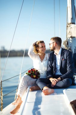 Düğün günü teknede, açık denizde güzel bir çift. Beyaz elbiseli zarif bir gelin ve lüks bir yatta denizde yüzen şık bir damat. Birlikte. Düğün günü..