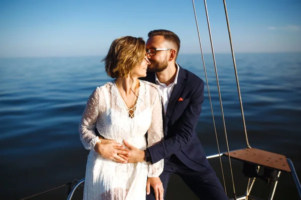 Beautiful wedding couple on yacht at wedding day outdoors in the sea. Beautiful elegant  bride in a white dress and stylish groom on the luxury yacht sailing down the sea. Together. Wedding day.