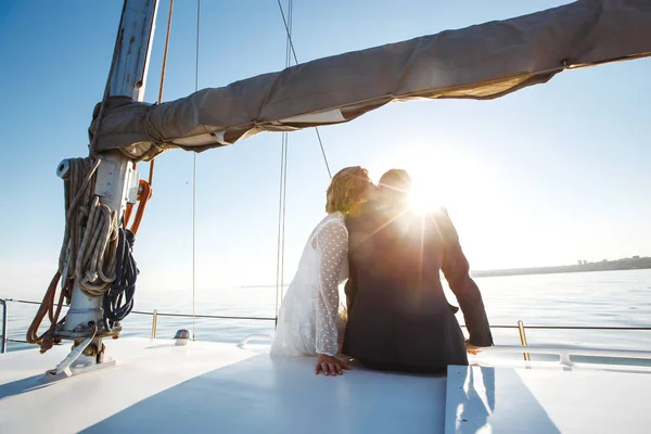 Beautiful wedding couple on yacht at wedding day outdoors in the sea. Beautiful elegant  bride in a white dress and stylish groom on the luxury yacht sailing down the sea. Together. Wedding day.