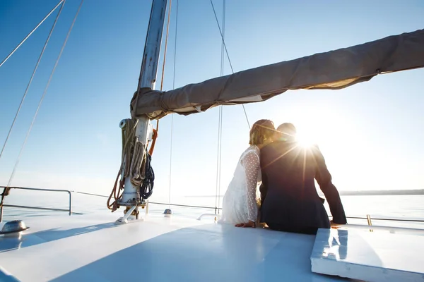 Beautiful wedding couple on yacht at wedding day outdoors in the sea. Beautiful elegant  bride in a white dress and stylish groom on the luxury yacht sailing down the sea. Together. Wedding day.