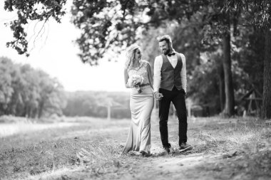 Gelin ve damadın şehvetli siyah beyaz foto 'su. Yeni evli çiftimiz düğün günlerinde parkta poz veriyormuş. Yakışıklı sakallı damat güzel gelini takdir eder ve öper. Birlikte.