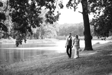 Gelin ve damadın şehvetli siyah beyaz foto 'su. Yeni evli çiftimiz düğün günlerinde parkta poz veriyormuş. Yakışıklı sakallı damat güzel gelini takdir eder ve öper. Birlikte.