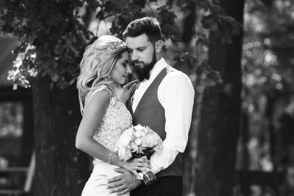 新郎新娘的性感黑白相间的胎儿 婚礼当天 一对时髦的新婚夫妇在公园里摆姿势 英俊的胡子新郎仰慕并亲吻漂亮的新娘 一起来 — 图库照片